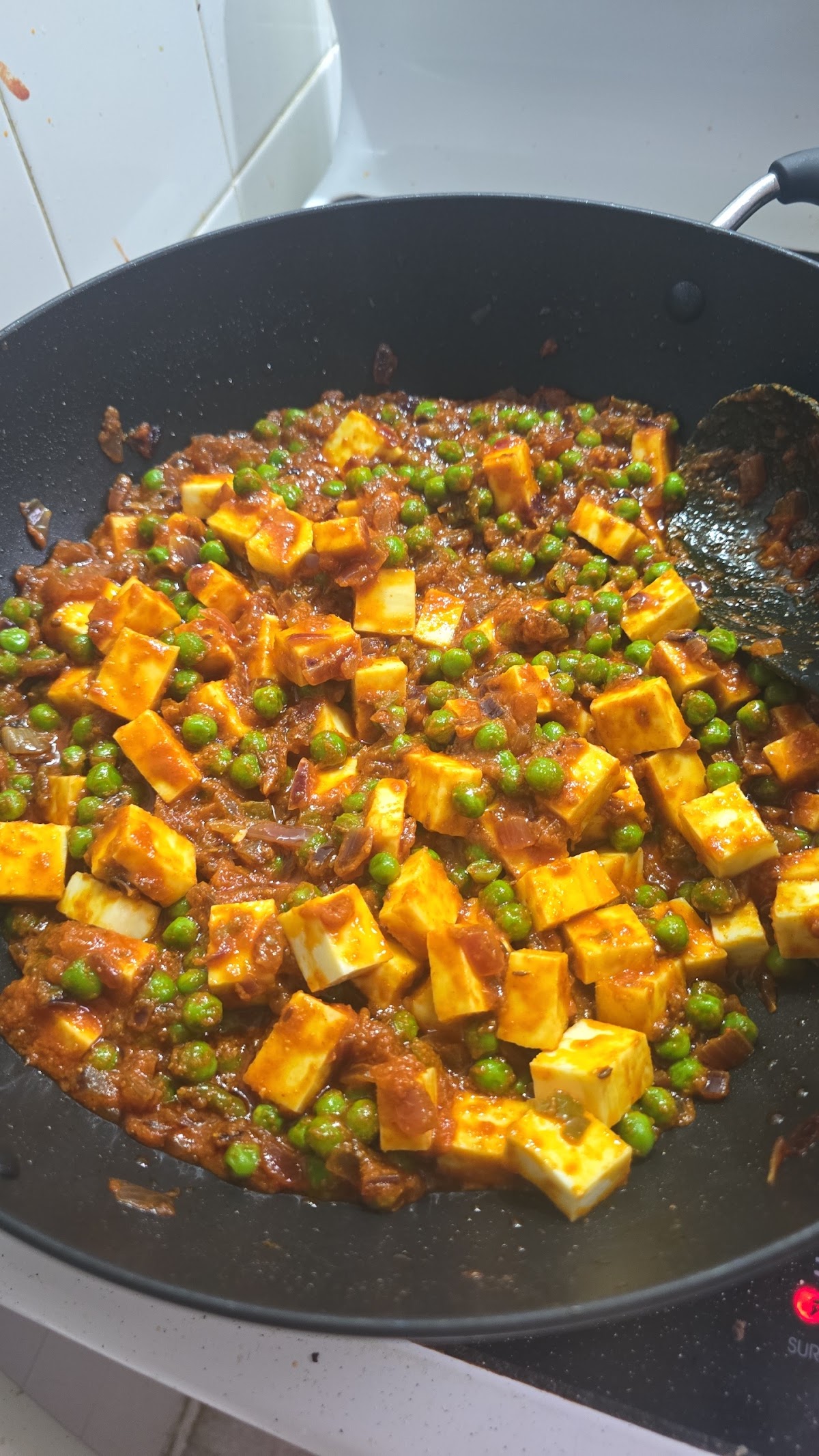 Matar paneer simmering in the wok at Rubina's Kitchen